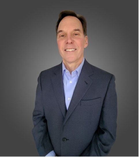 Smiling man in suit jacket, gray background