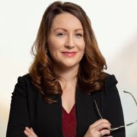 Smiling professional woman holding eyeglasses