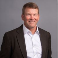 Smiling man in suit jacket on gray background