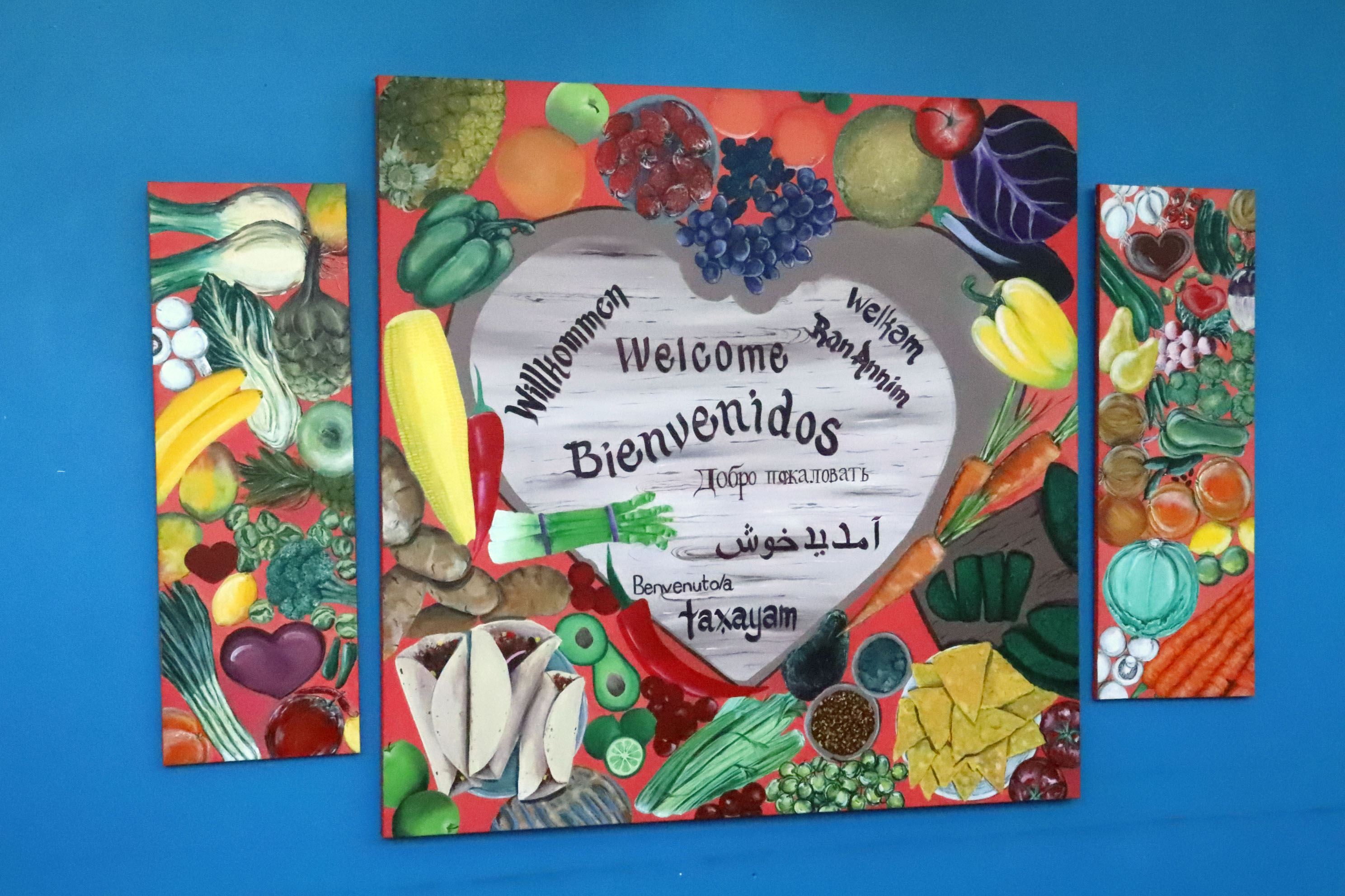 Mural of fruits and vegetables hanging on blue wall