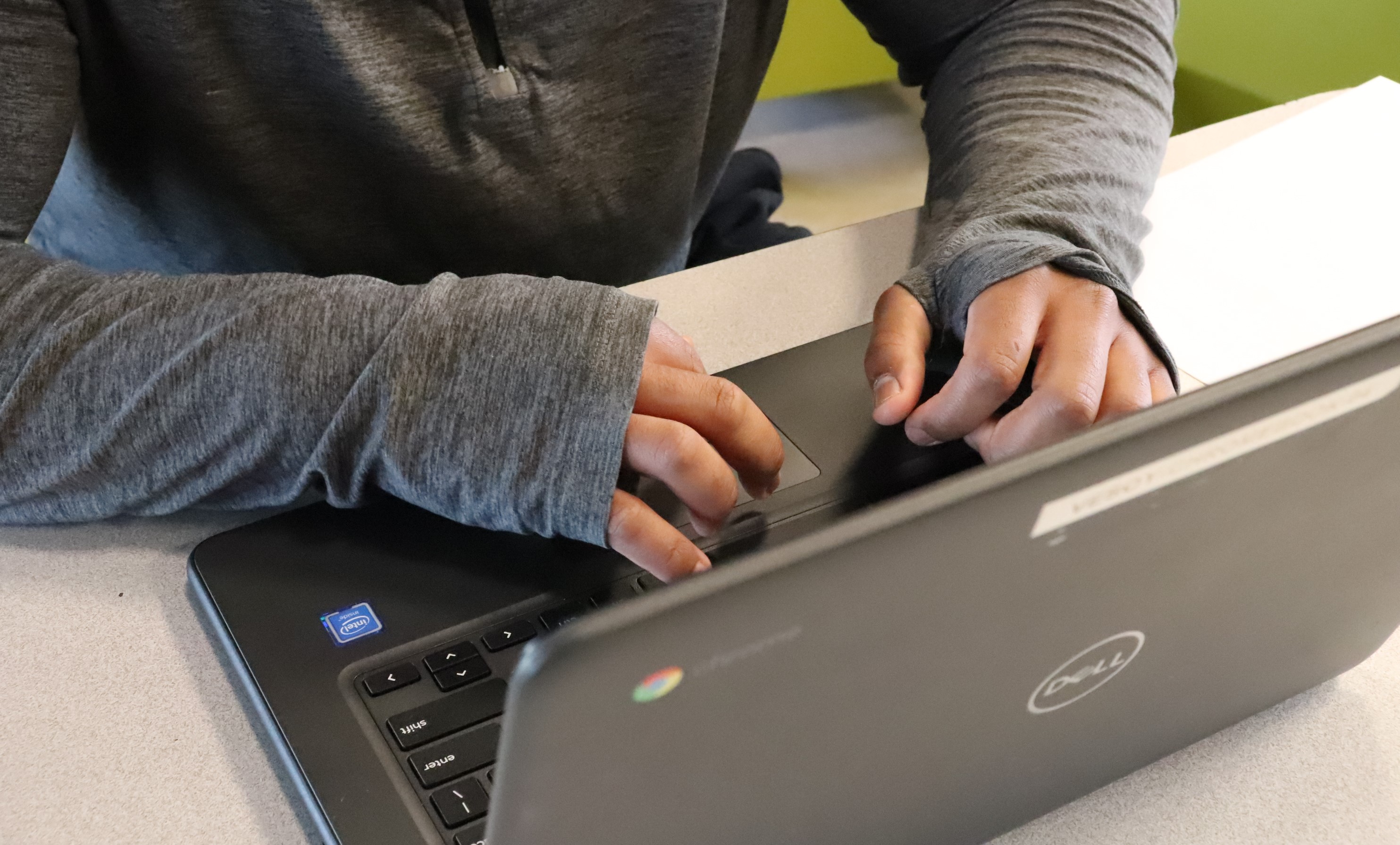 two hands typing on a laptop