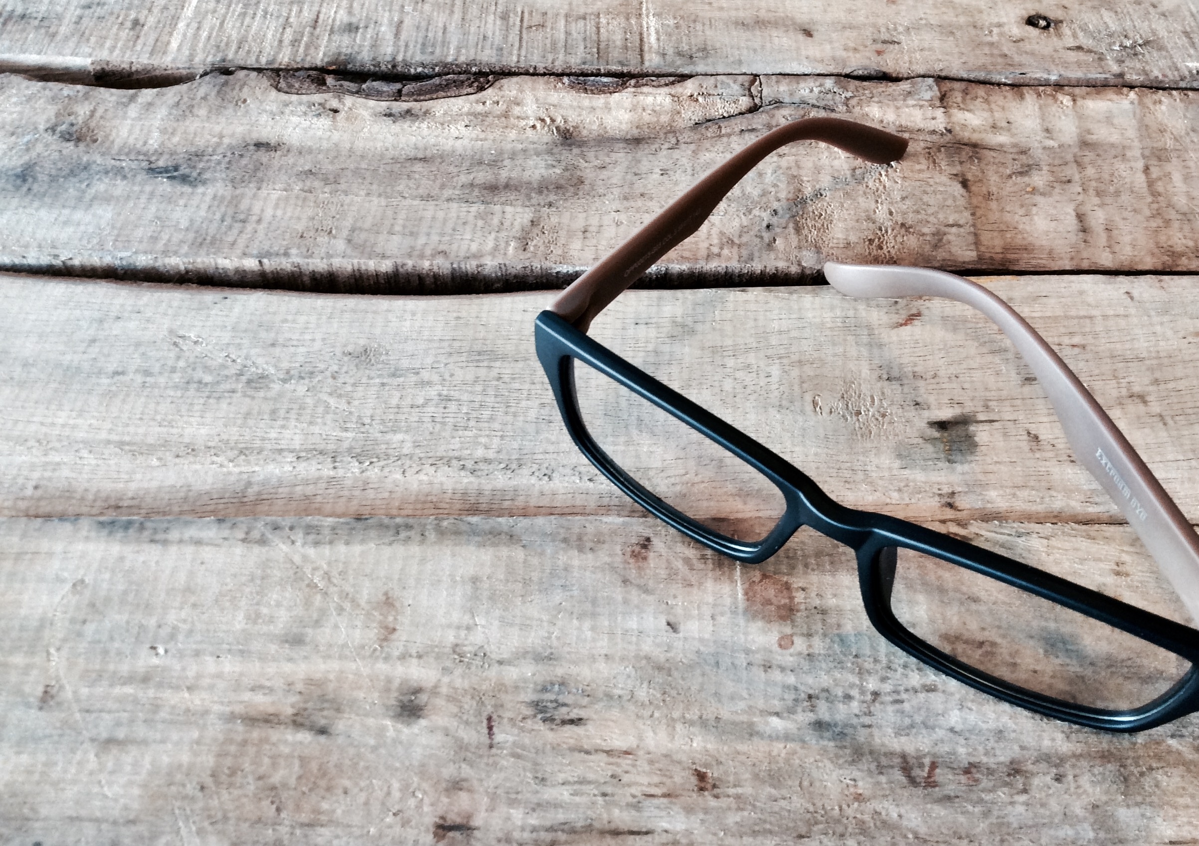 Black eyeglasses on a rustic wooden table