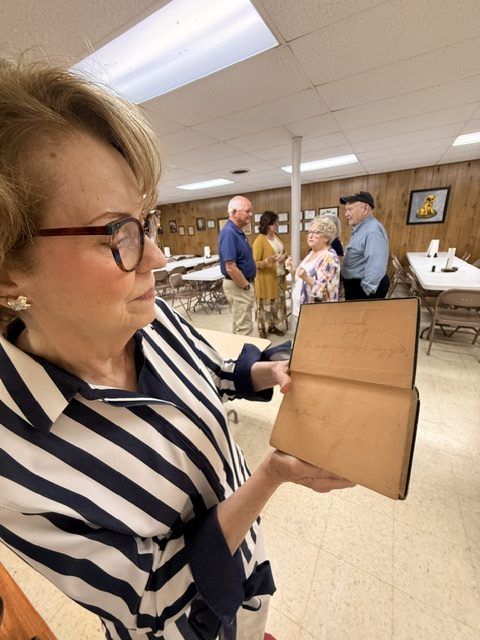Lynne showing Tamera Jack Daniel's handwritten inscriptions within the book