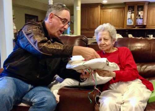 Photo of Jess helping Mom unwrap Christmas gifts