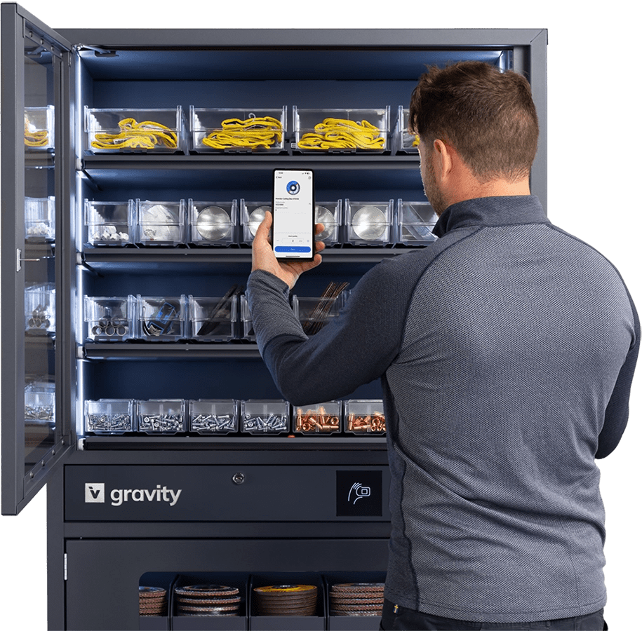 Man scanning items in an open Gravity storage cabinet using a smartphone, with organized compartments containing various tools and materials.