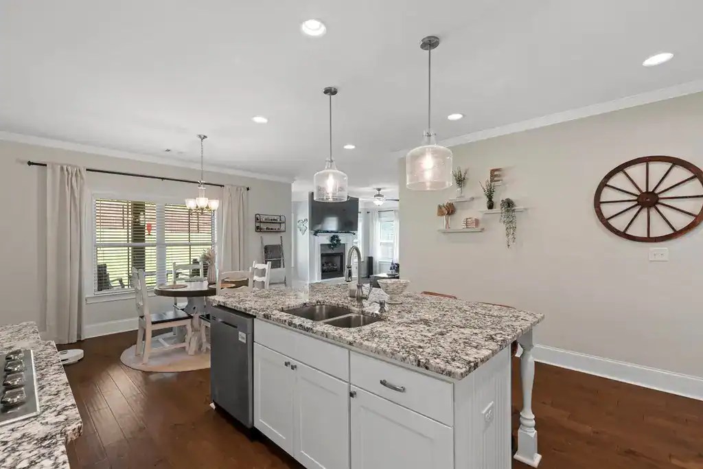 Beautiful modern kitchen with granite countertops, white cabinetry, and farmhouse decor, perfect for contemporary home styles.