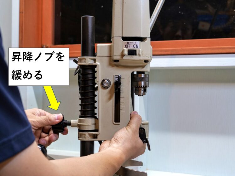 角ノミ本体ユニットを保持して昇降ノブを緩める