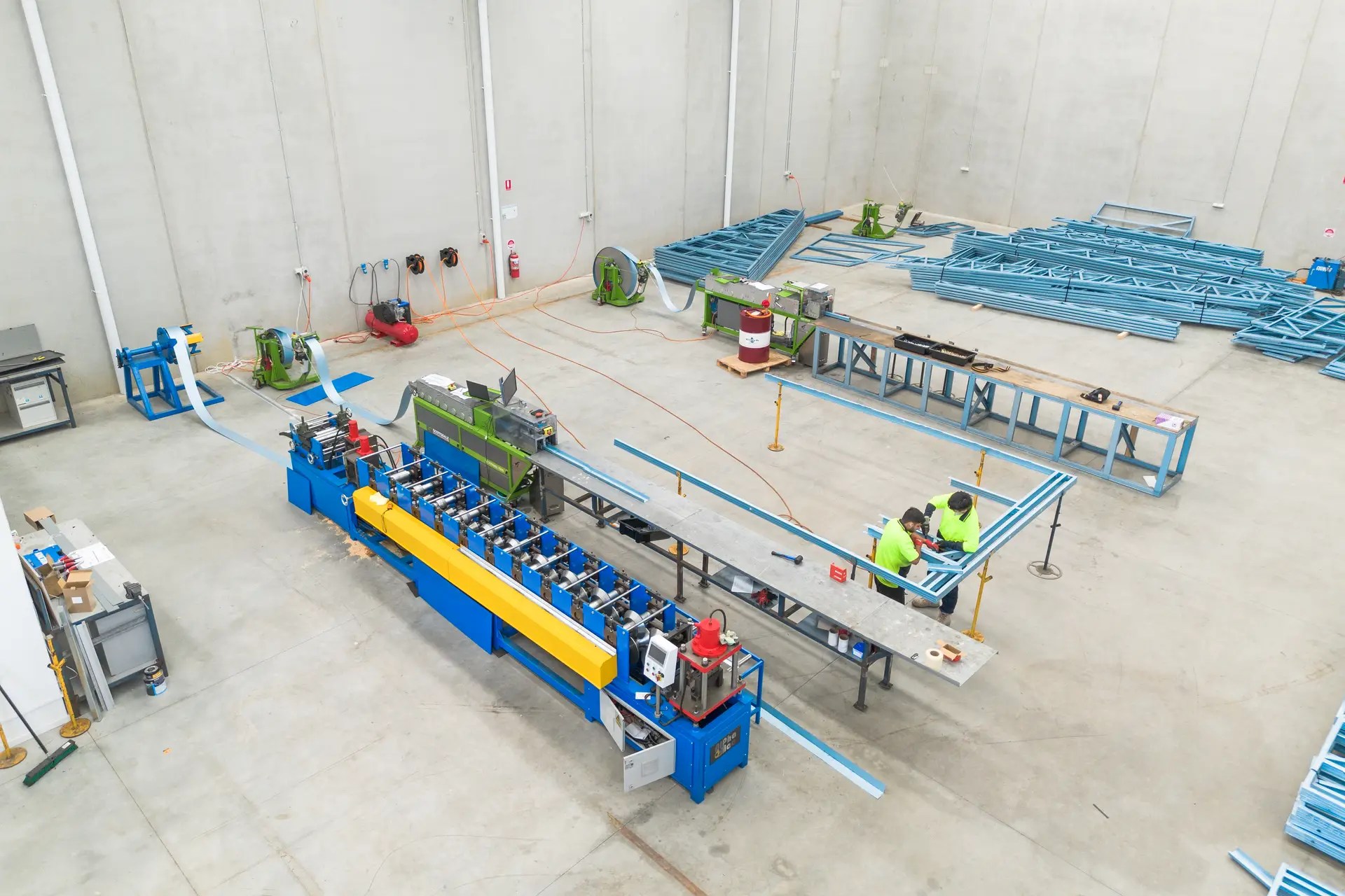 Top down view of two workers assembling steel wall frame in ISG Frames Facility in Melbourne