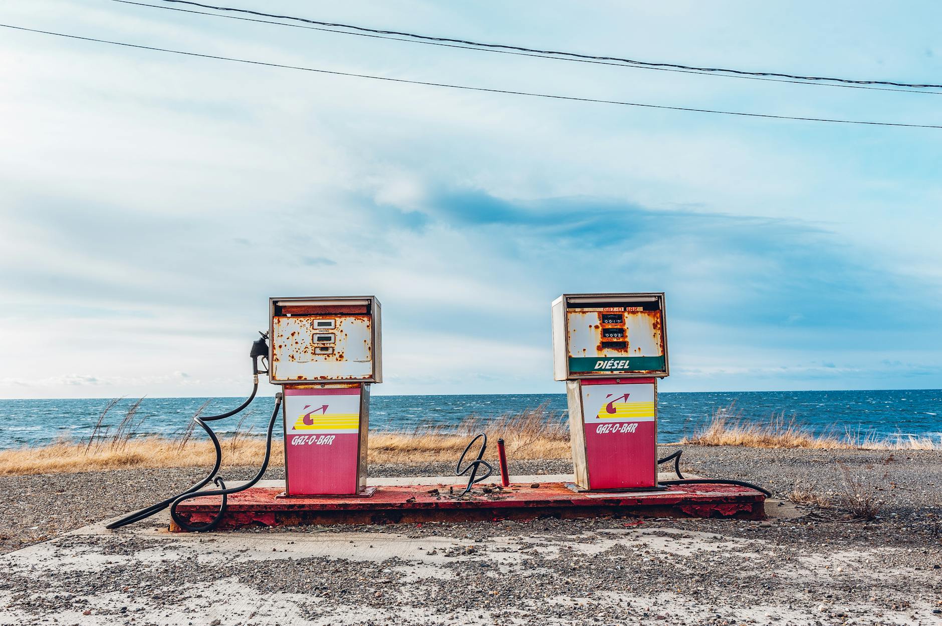 white and pink gasoline station near ocean
