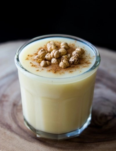 A small glass of boza topped with leblebi and a sprinkle of cinnamon.