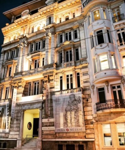 Pera Museum exterior at night, an ornate building illuminated by warm lights.