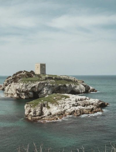 A small, square stone castle tower on a rocky island in the Black Sea, off the coast of Şile.