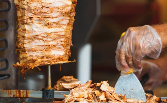 Chicken döner roasting on a vertical spit.