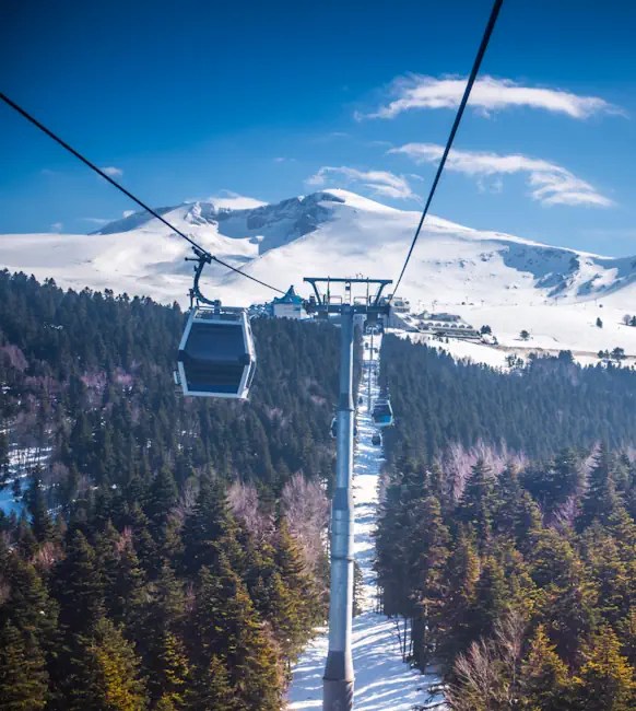 Snowy Uludağ mountain with cable car cabins overlooking forested slopes near Bursa.