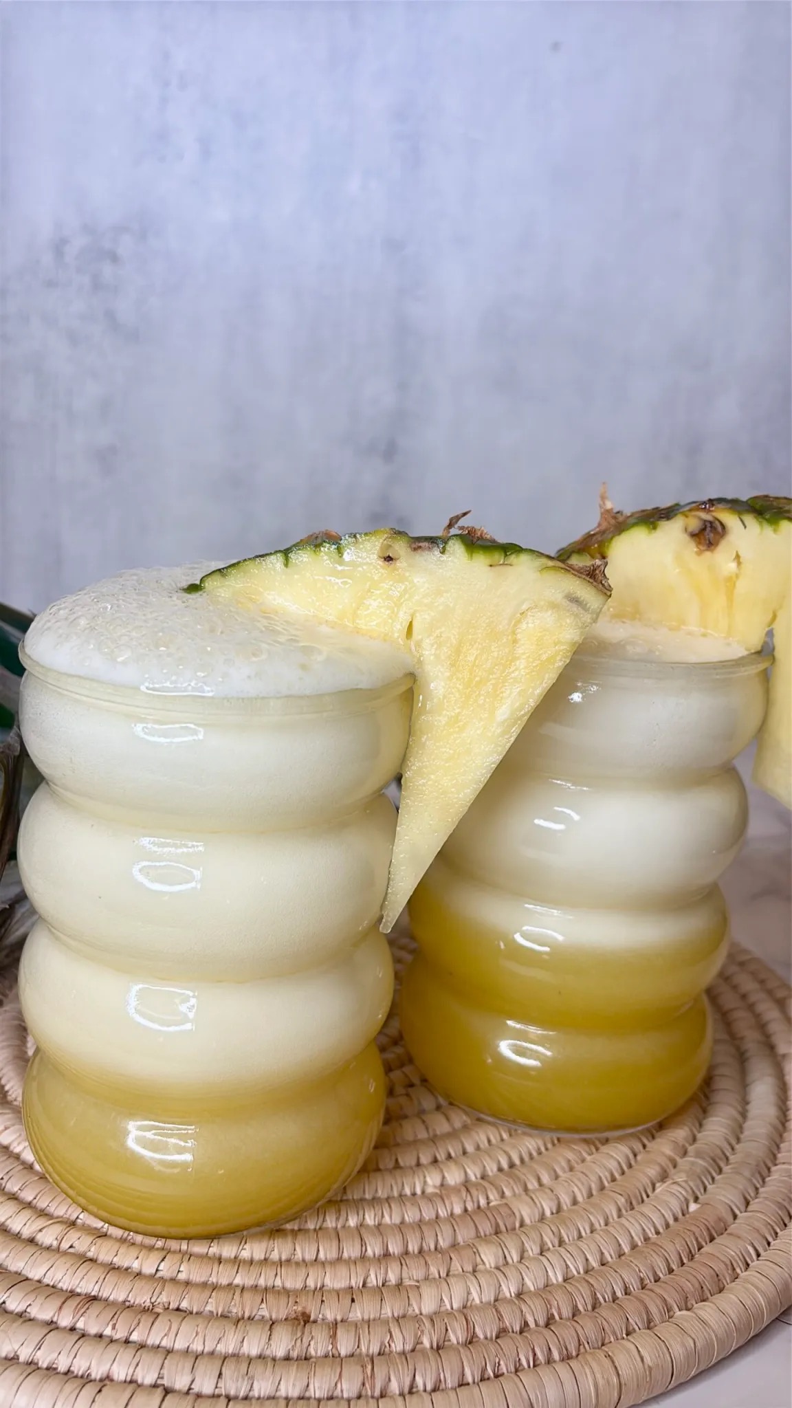 pineapple soda in a bubble glass with slices of pineapple on the side