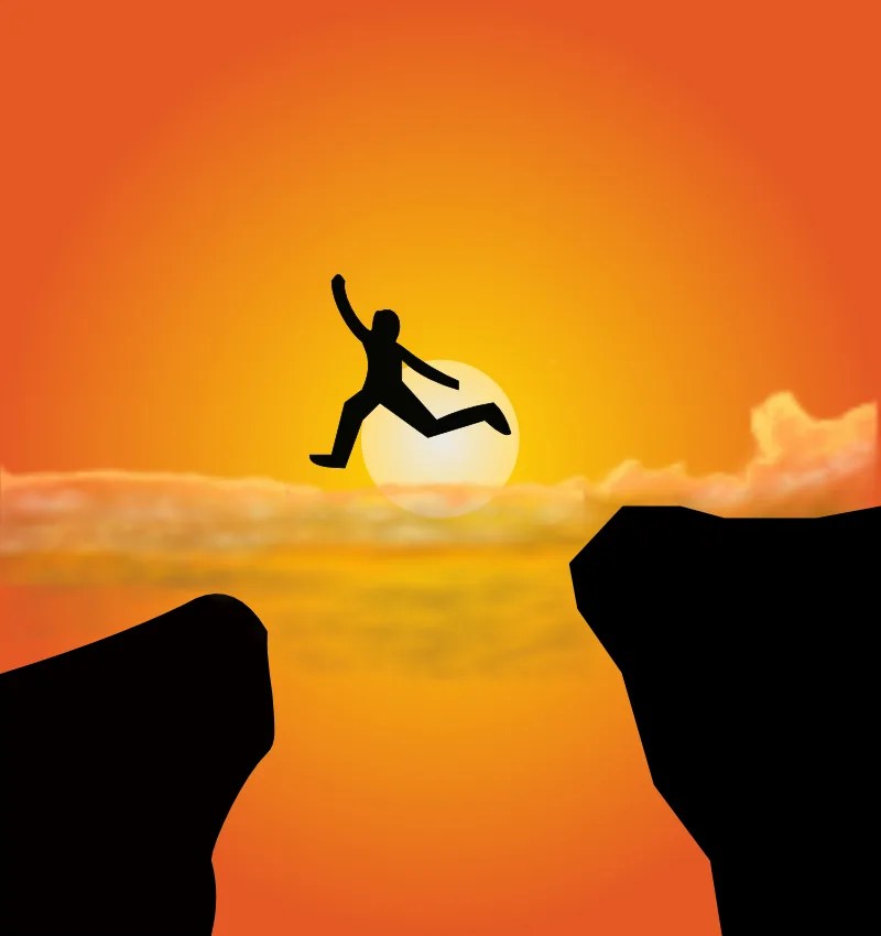 silhouette of person leaping over a chasm