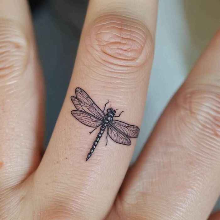 Delicate Dragonfly with Fine Line Detailing on the Finger tattoo