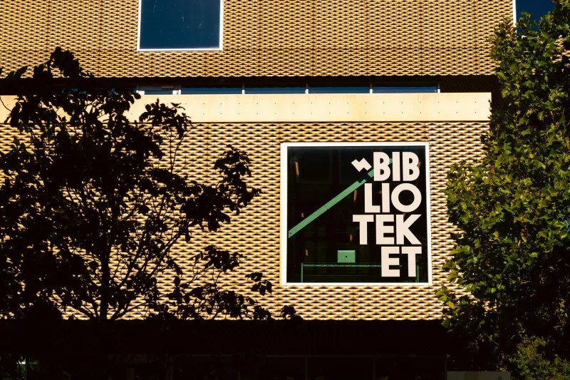 Gevel van Biblioteket Rentemestervej in Kopenhagen met het woord "Biblioteket" groot op de muur.