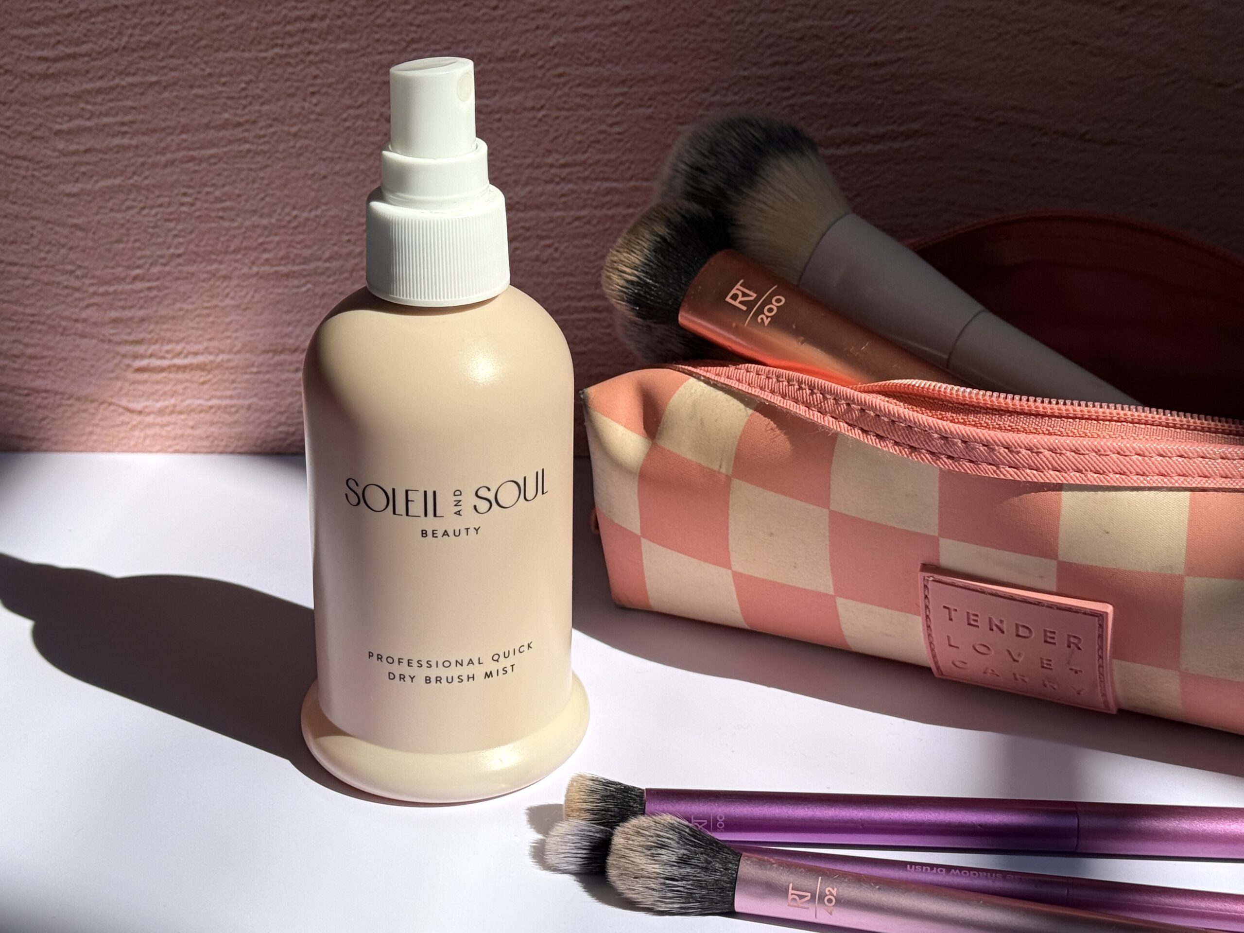 Makeup brushes and brush cleaner lie in the sun