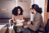 Person confidently sitting in an interview setting, engaging in conversation with an interviewer