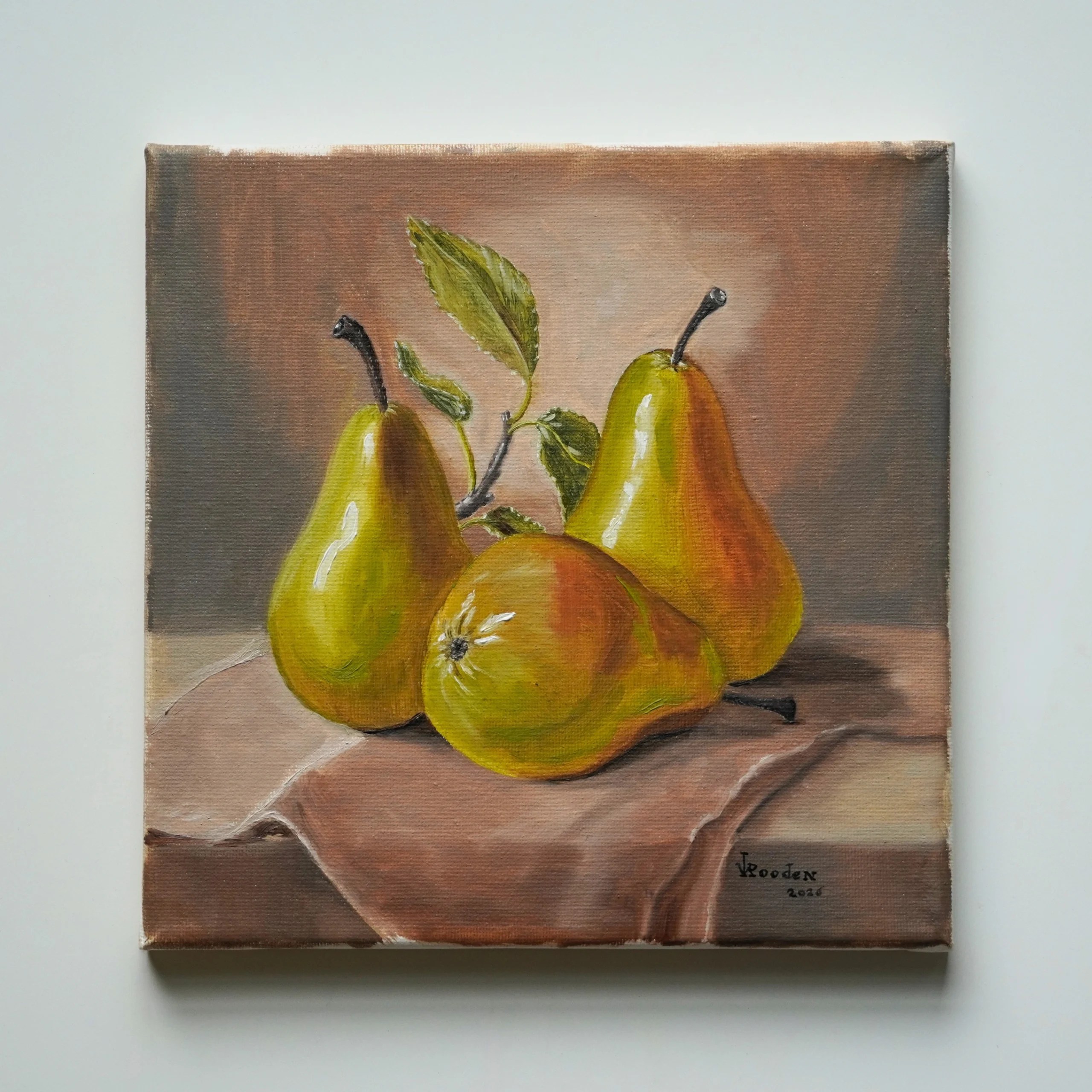 Still Life with Pears, an original oil painting by JVRooden featuring three golden-green pears with leaves arranged on softly draped fabric.