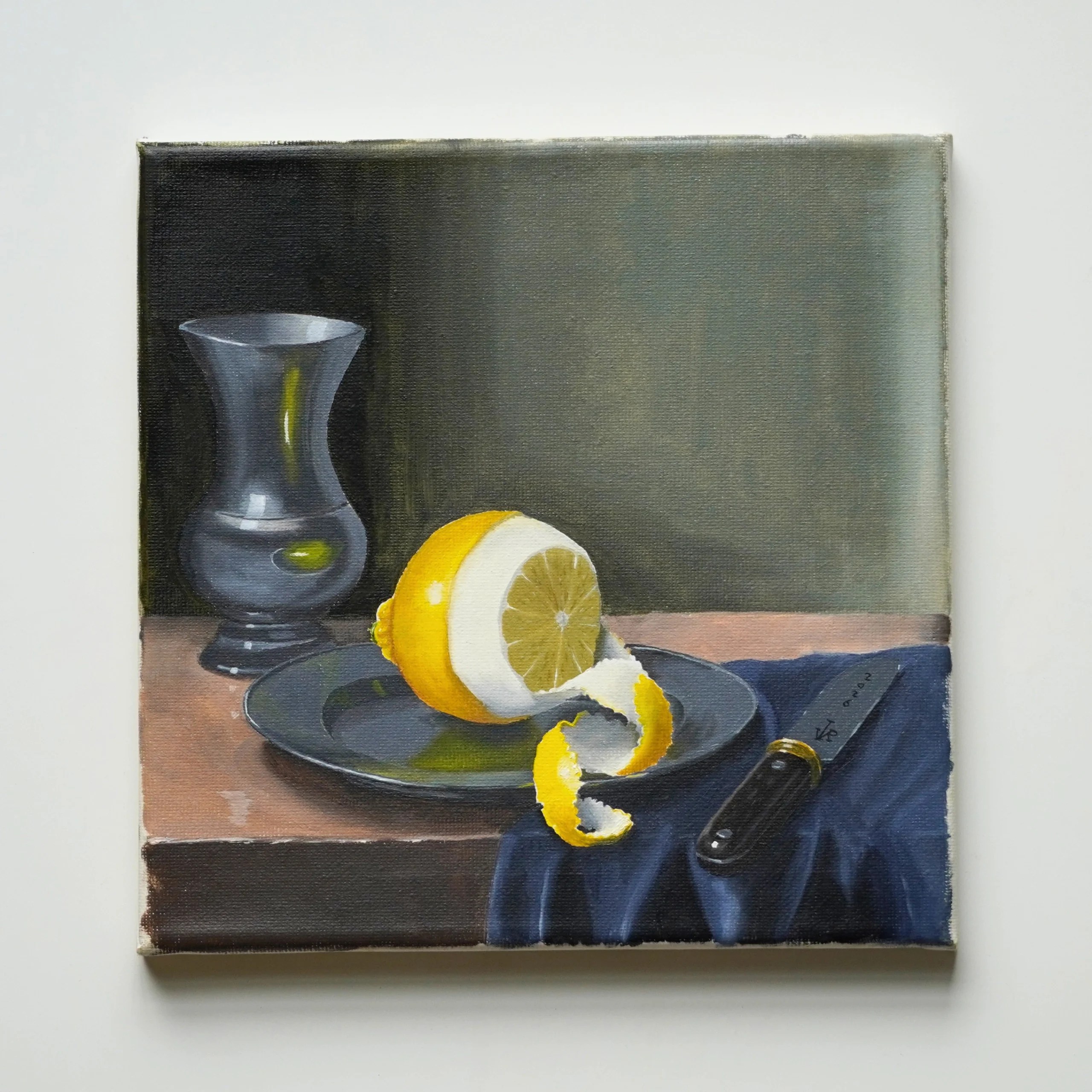 Still Life with Lemon, an original oil painting by JVRooden featuring a partially peeled lemon on a dark plate with a glass vessel and knife.
