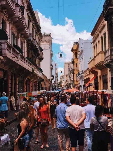 people standing on road beside market and high rise buildings