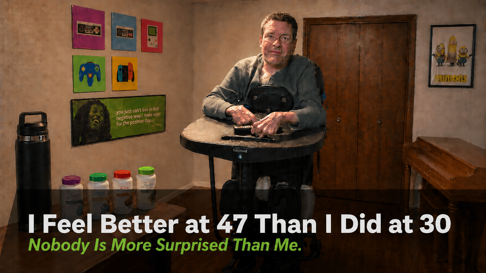 Jamie Jordan upright in a standing frame in his office, with supplement bottles and a large water tumbler lined up in front of him, under the title "I Feel Better at 47 Than I Did at 30. Nobody Is More Surprised Than Me."
