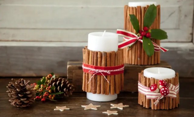 A simple craft showing a plain pillar candle wrapped tightly with fragrant cinnamon sticks and tied with rustic twine.