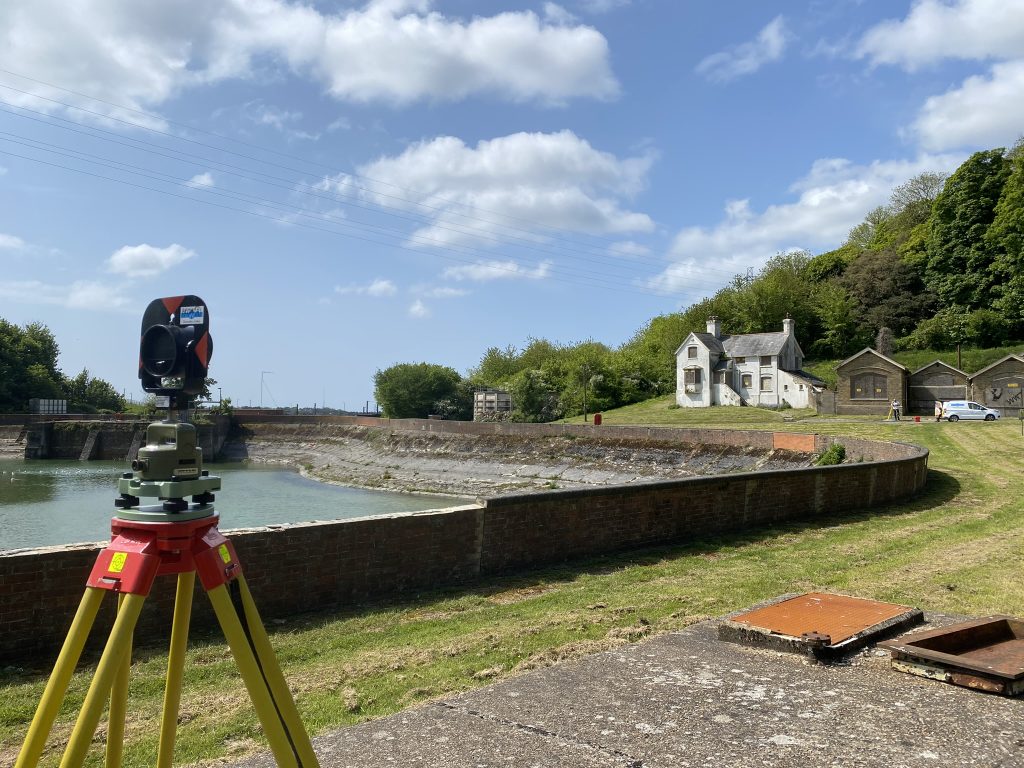 round prism on tripod surrounding water reservoir for monitoring