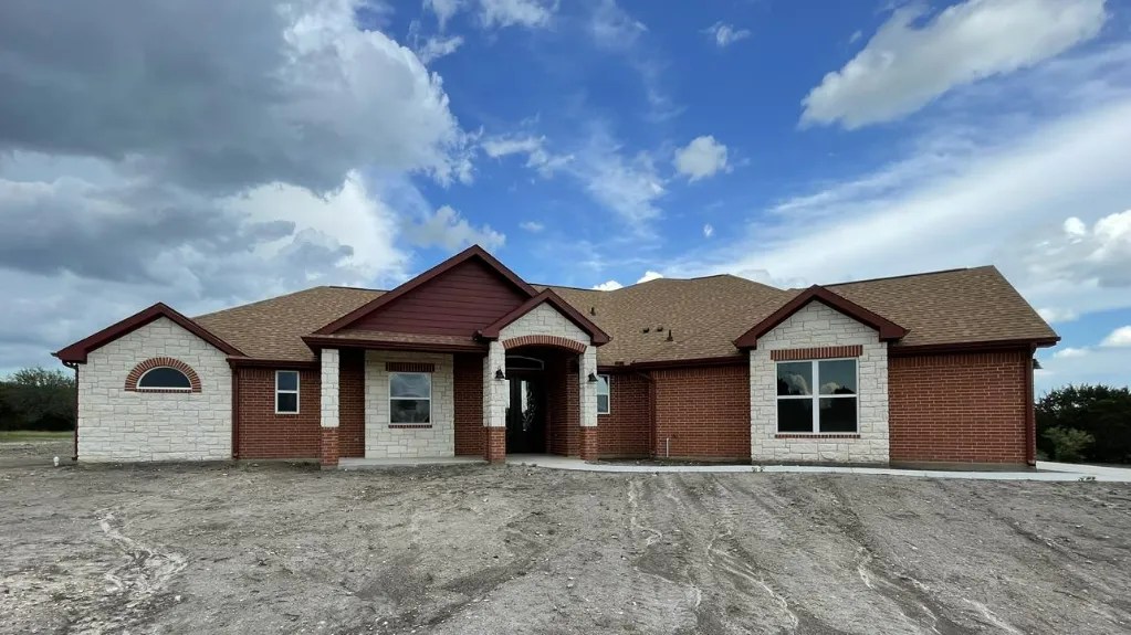 Single story brown brick and tan home