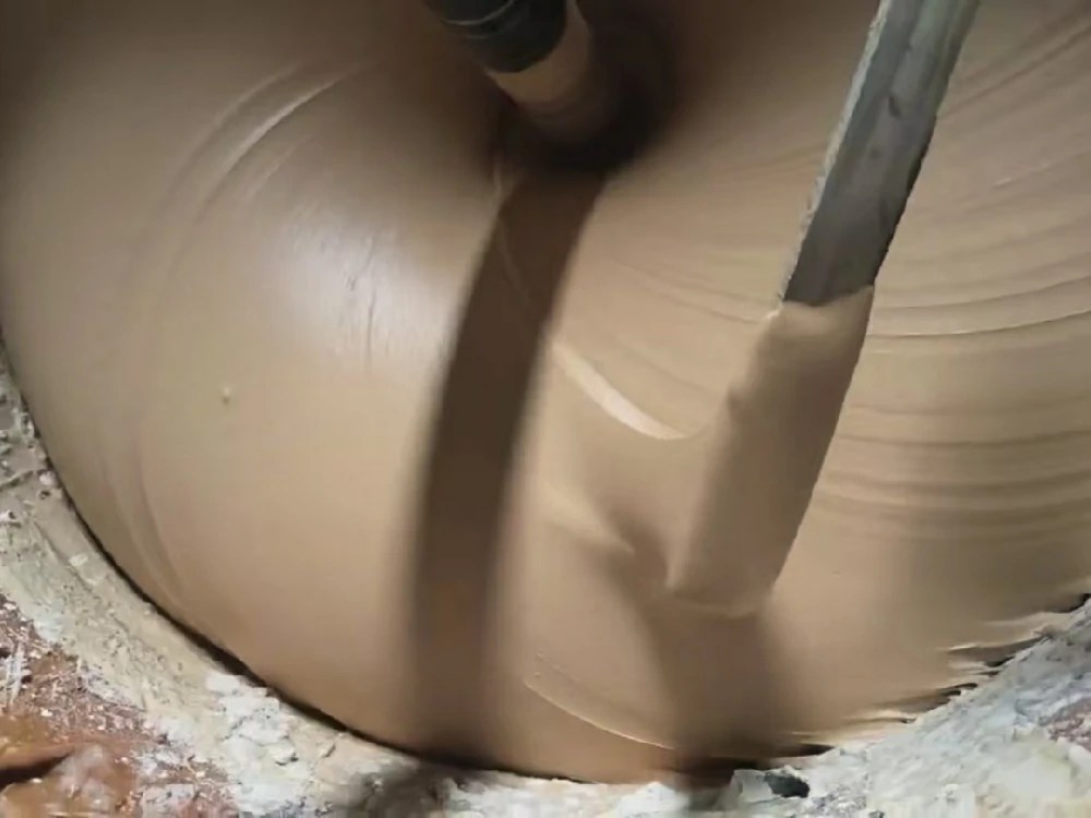 Adhesive flows in a continuous stream when lifted with a wooden stick.