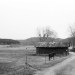 A pastoral scene of a horse, barns, and pastures