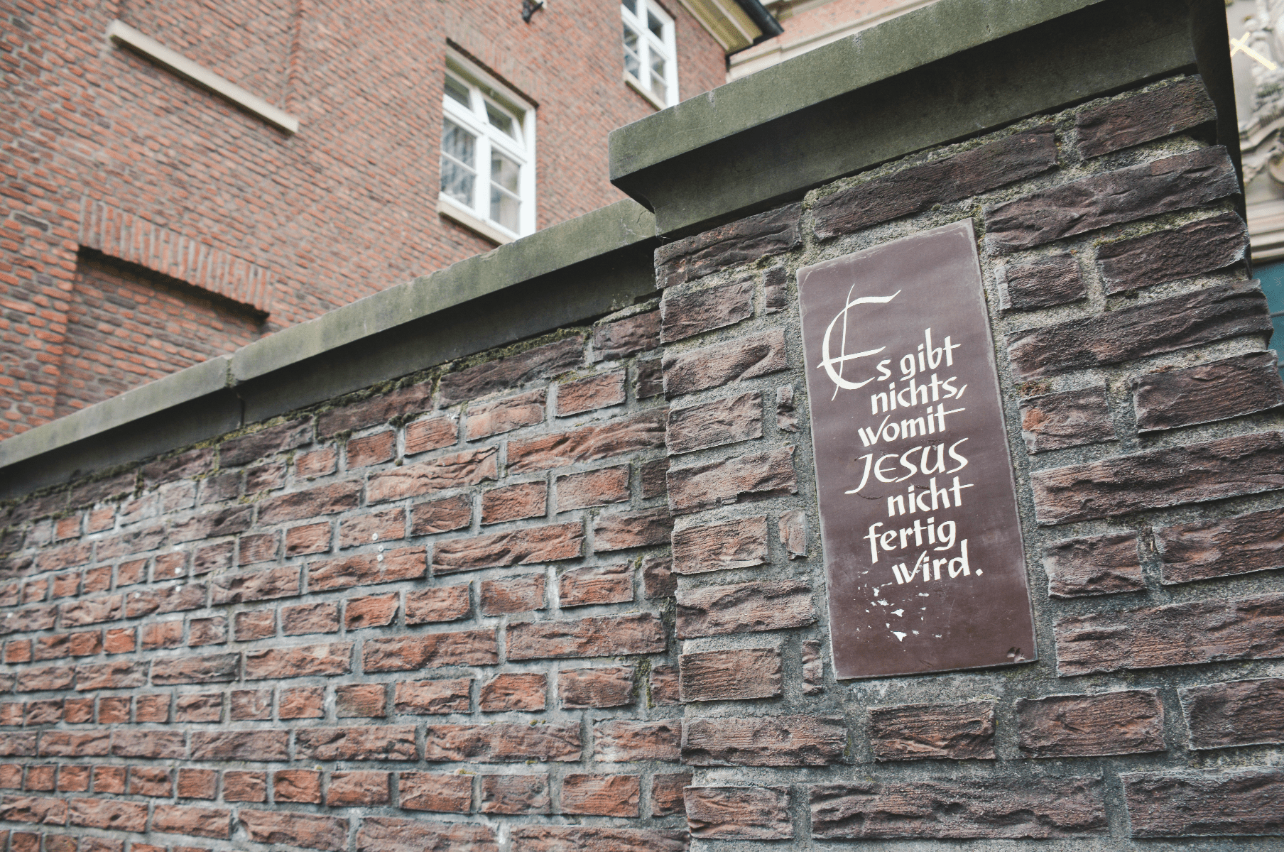 The plaque outside of a church in Hamburg that reads "There is nothing in which Jesus is not finished"