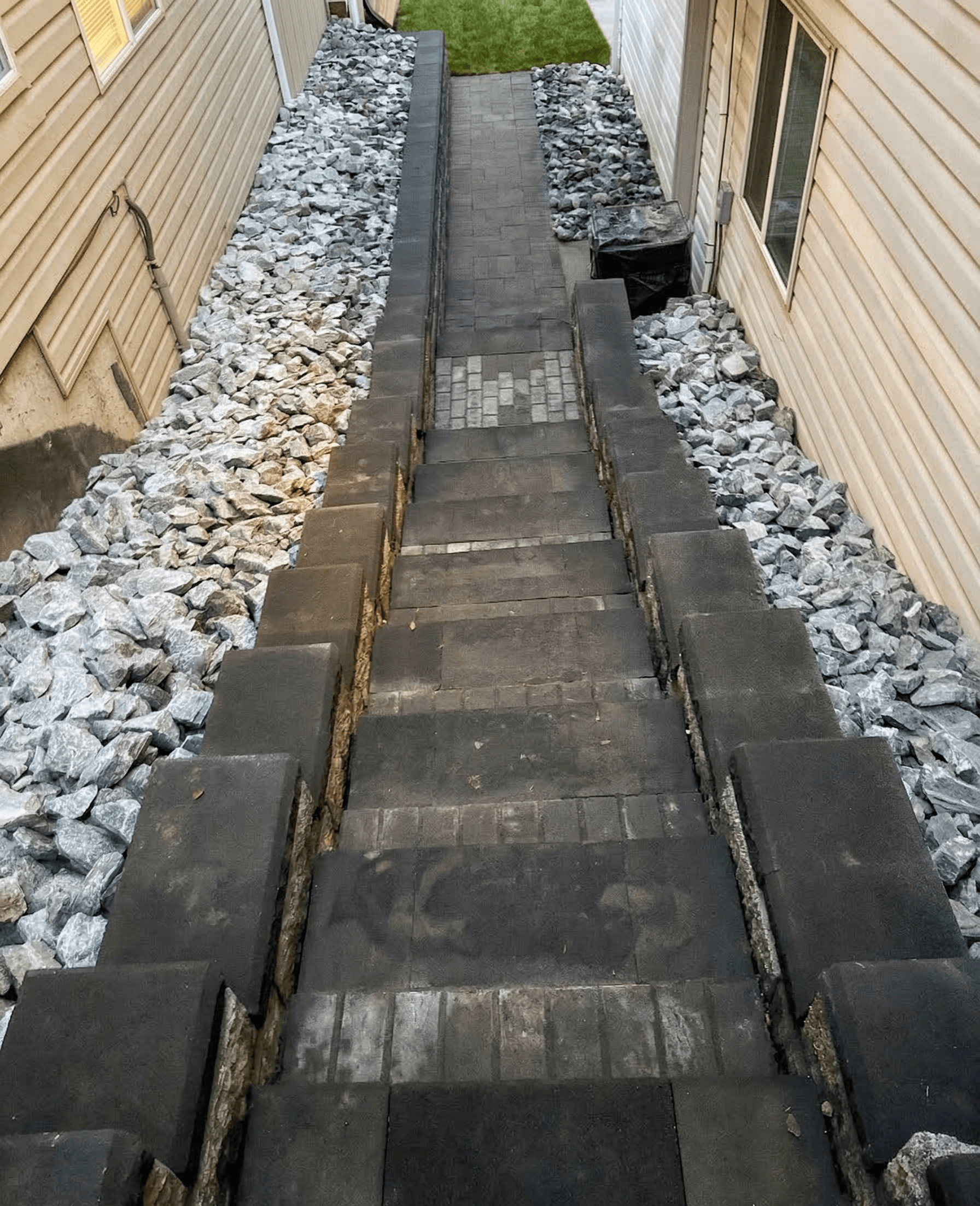 Close up of a zero-maintenance paver path and retaining wall installation for a narrow property boundary in British Columbia.
