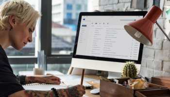 A wp,am sottomg at a desk using Gmail