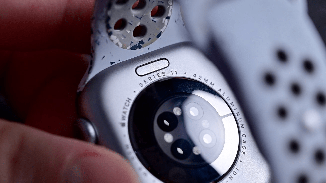 A high-detail close-up of the back of an Apple Watch Series 11, showing the third-generation optical heart rate and blood oxygen sensors used for accurate health tracking.