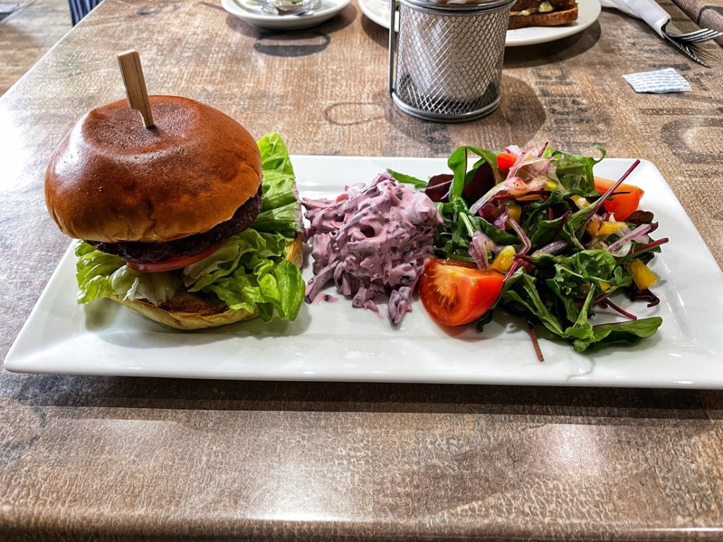 A burger on a plate with salad at Eden Cafe in Whitley Bay