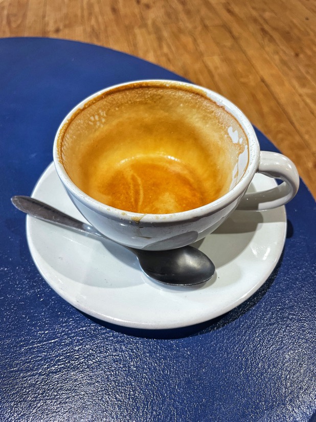 A white cup and saucer on a blue table with the remains of a latte in the cup at the The Chapel in Ormskirk