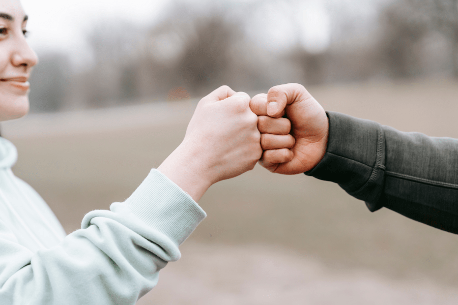 two people's hands fist-bumping