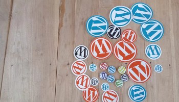 WordPress pins and stickers on a wooden floor