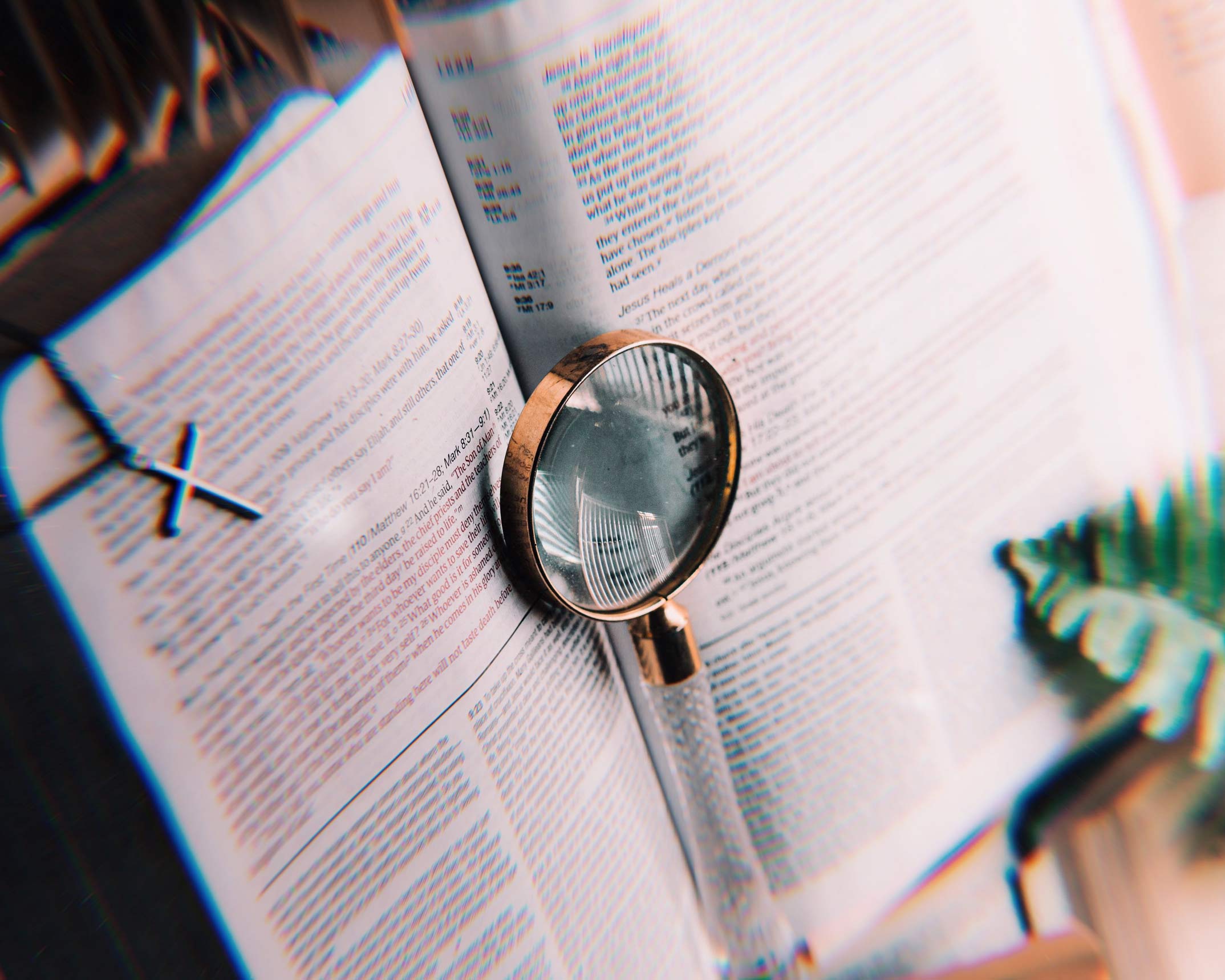 a looking glass and a crucifix on a bible