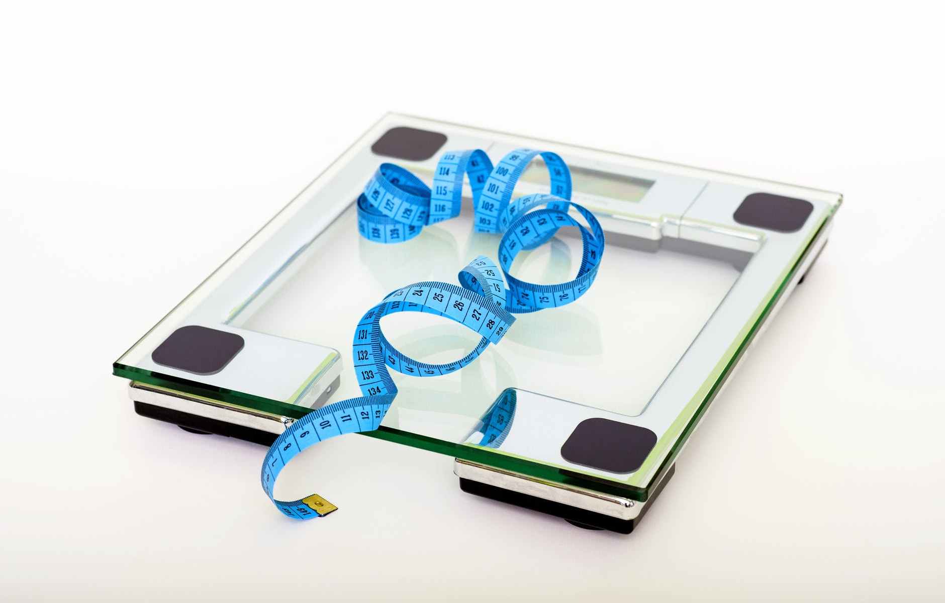 blue tape measuring on clear glass square weighing scale