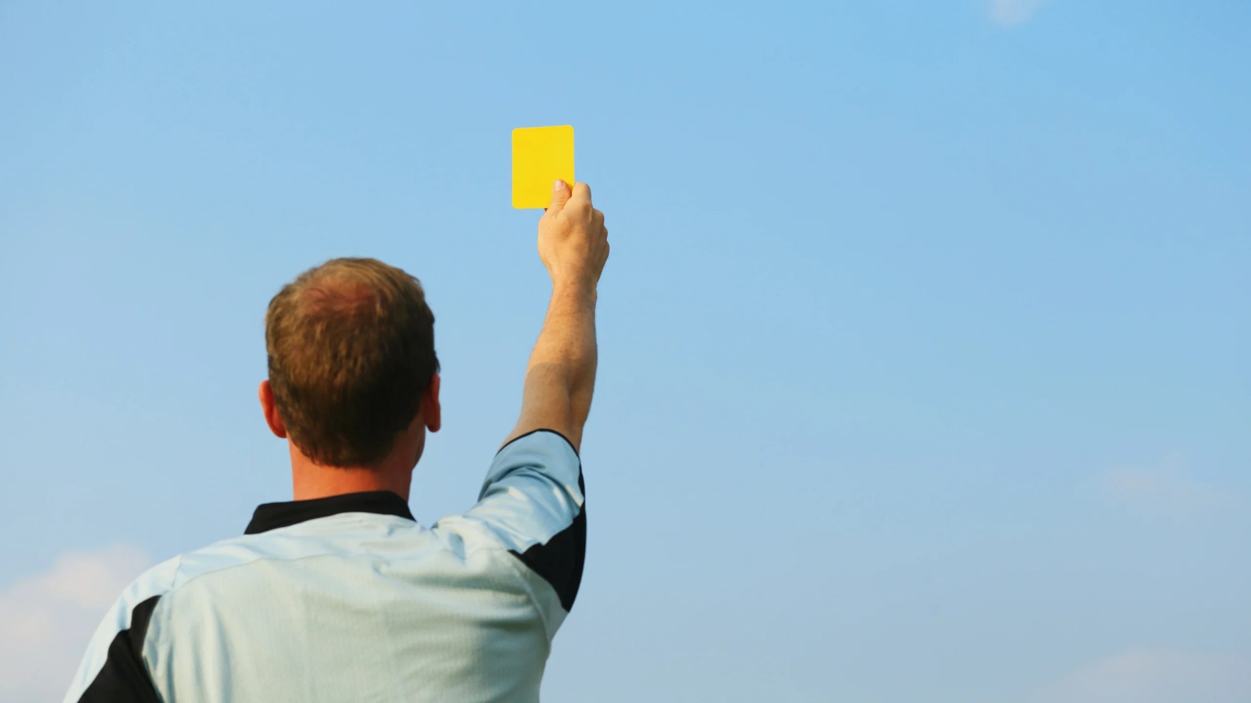 A referee showing a yellow card.