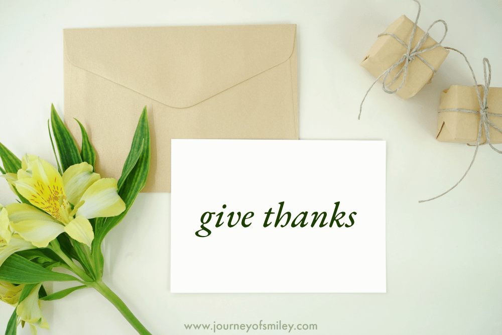 a letter and an envelop and on the letter is written 'give thanks' and a flower on a table on Journeyofsmiley blog