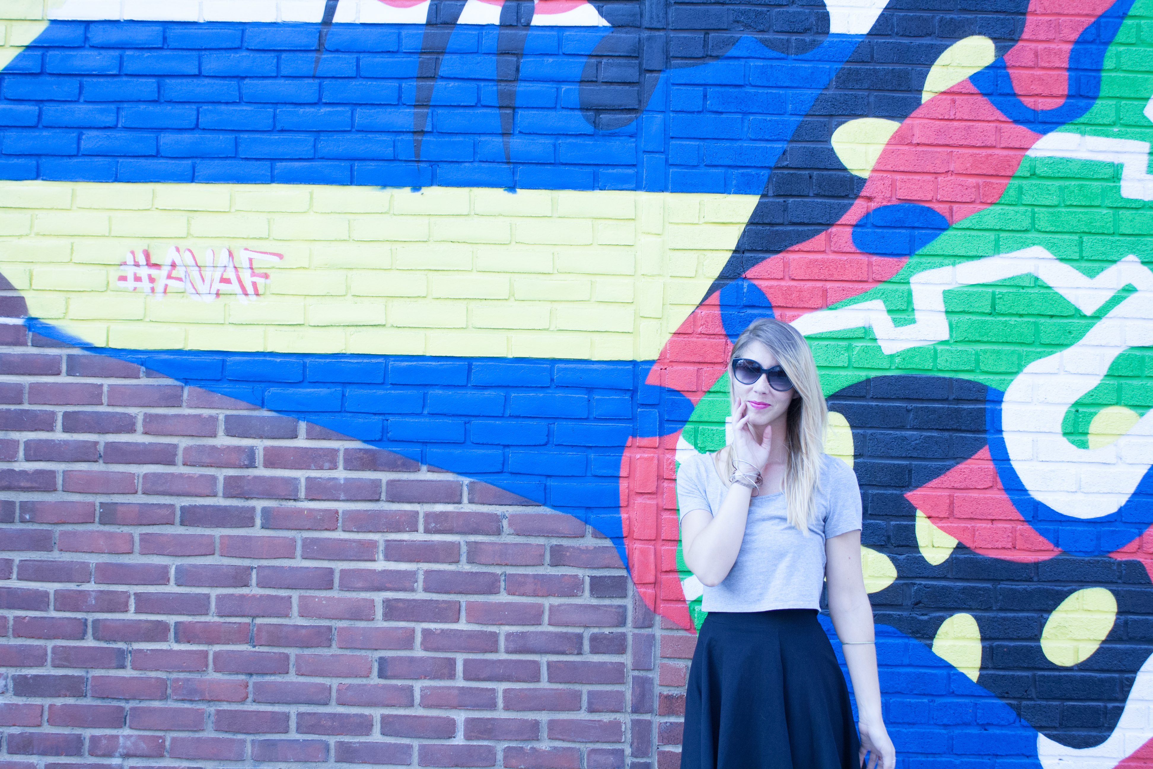 Street mural in Brooklyn with woman getting he portrait taken in front