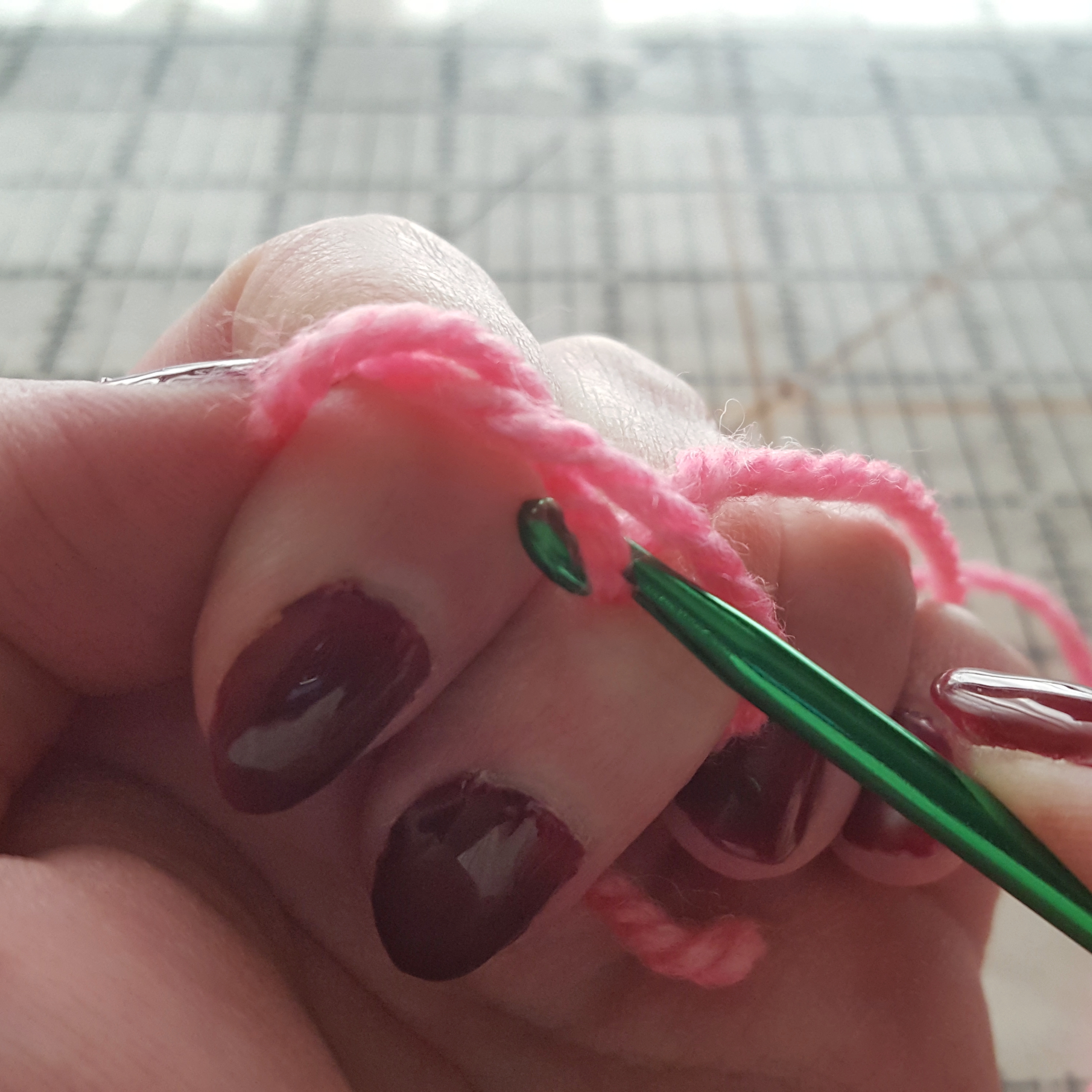 crochet hook pulling yarn through loop