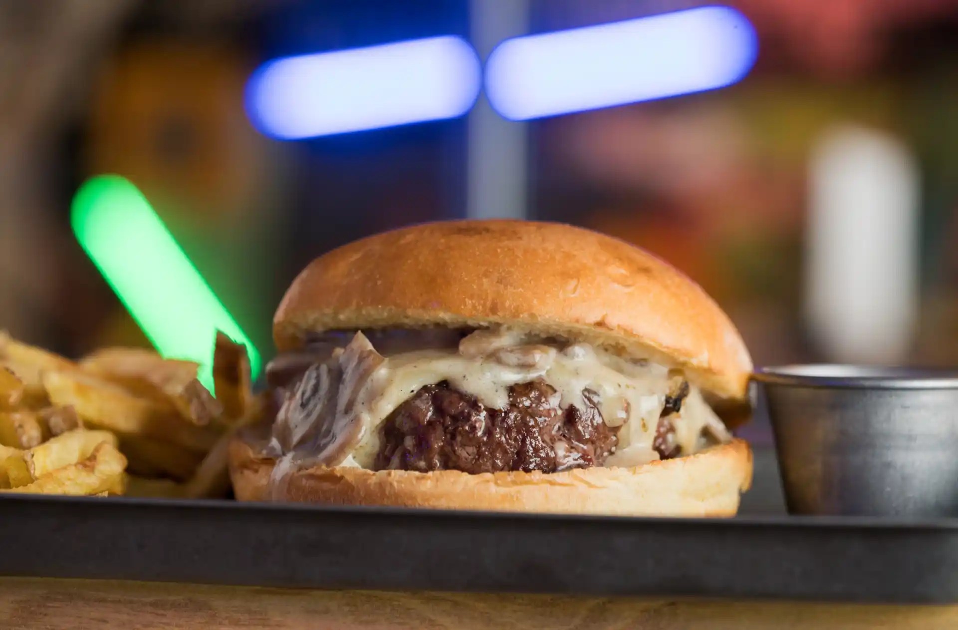 Dark, textured industrial-style wall with a bright vertical tube light on the right and a warm hanging bulb in the upper center, creating an edgy, modern background.