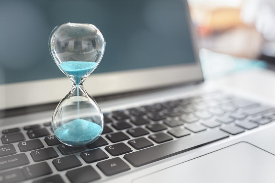 Teal sand hourglass on laptop