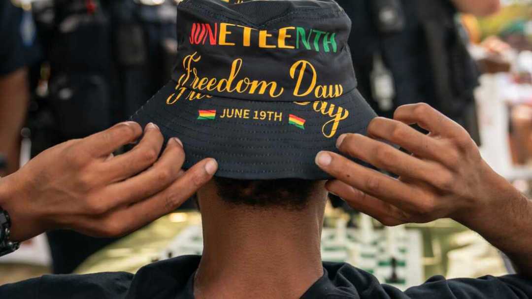 An attendee adjusts his Juneteenth-themed hat during a neighborhood Juneteenth festival on June 17, 2023, in Washington, DC.